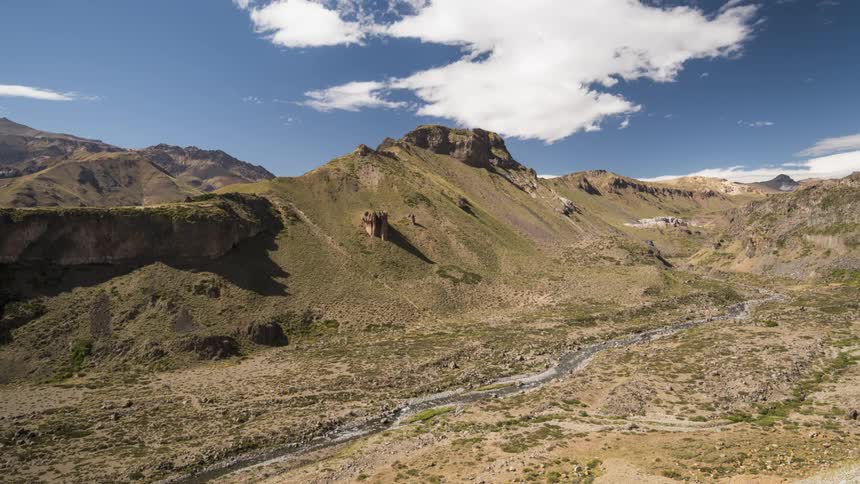 Mountain scenery with hills against a partly cloudy blue sky