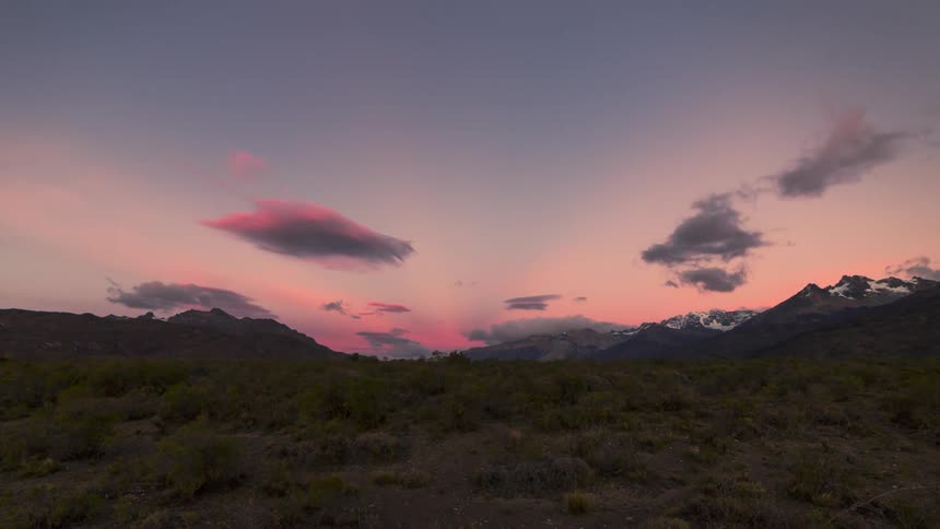 Natural landscape of snowy mountains on the horizon with the sun rising and the sky changing tones