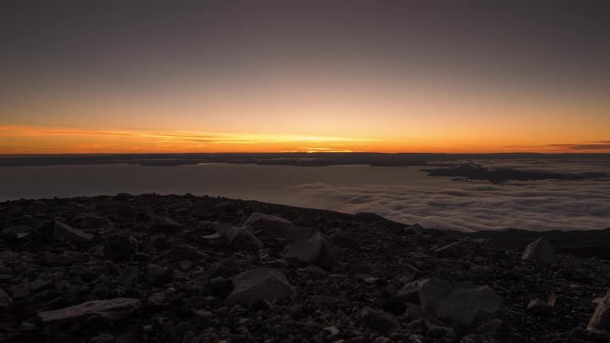 The sun is setting above ocean water in the horizon