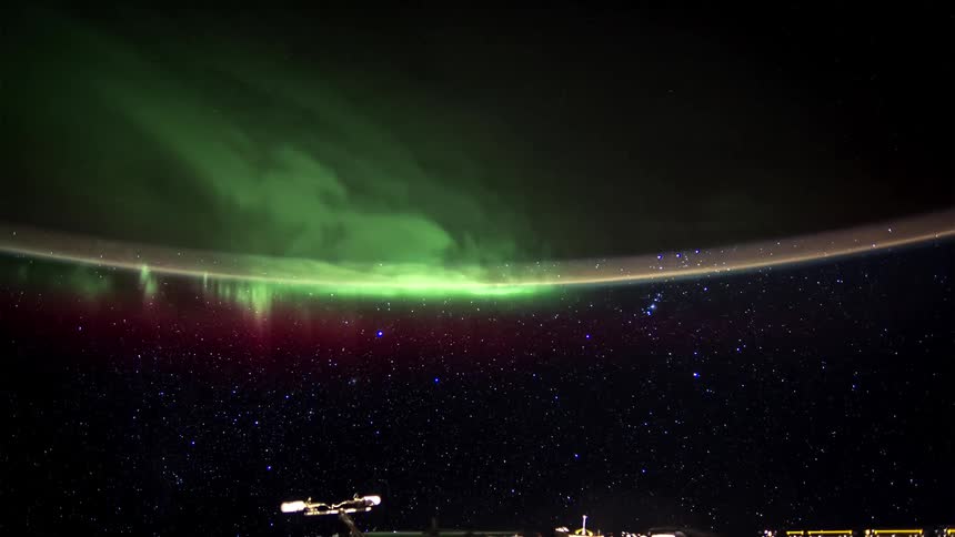 Aurora borealis with shades of green over a starry sky with the curvature of the earth visible
