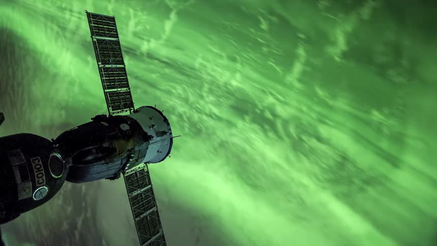 Satellite overlooking a green streaky planet below