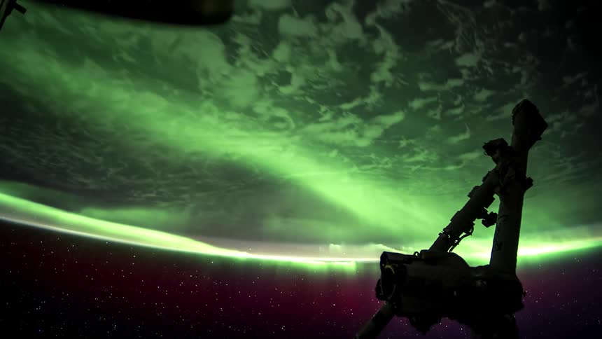 Aurora covers the earth as it rotates under a satellite
