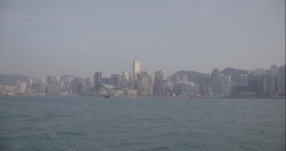 Skyline of a large city as seen across the river from a moving boat