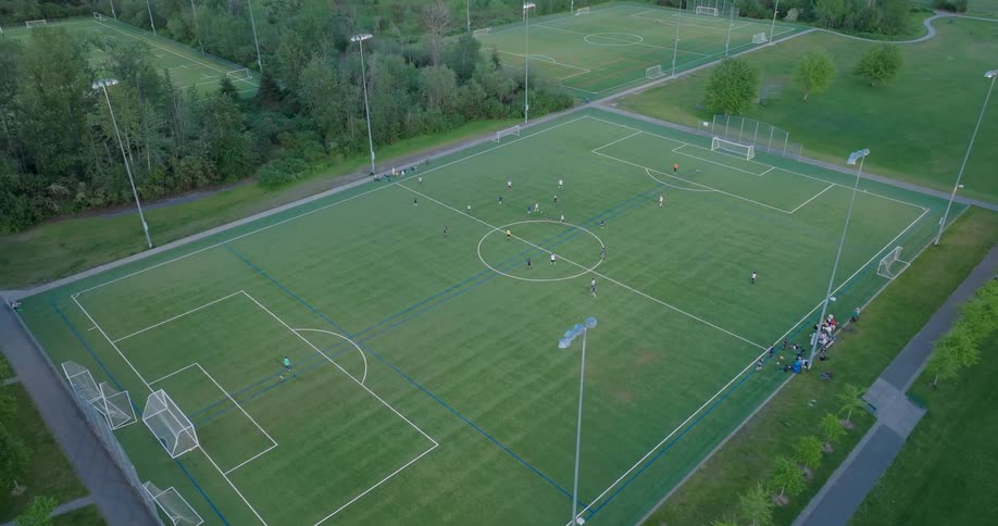Subtle orbit around a pickup game of soccer at a city park