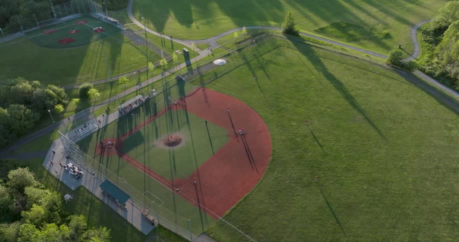 Youth league teams playing a game of baseball on a sunny day