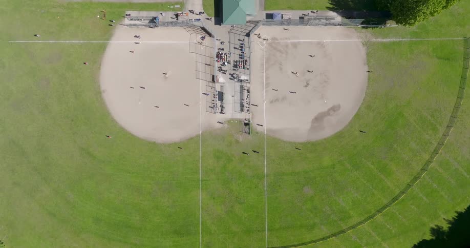 Slow descent over two baseball fields with little league games underway