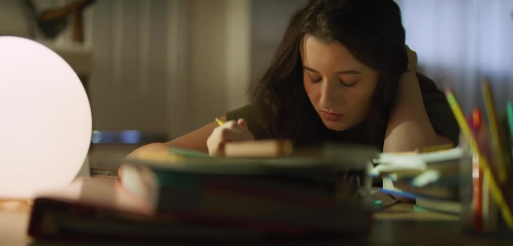 A female student is studying and writing notes