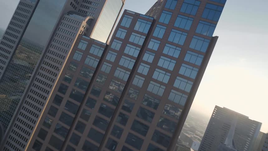 Birds-eye view of tall skyscrapers in Dallas, Texas while the sun is setting in the horizon