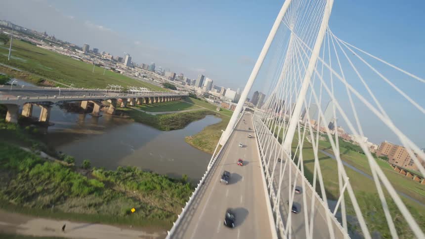 Multiple vehicles driving on Margaret Hunt Hill Bridge over the Trinity River in Dallas, Texas.