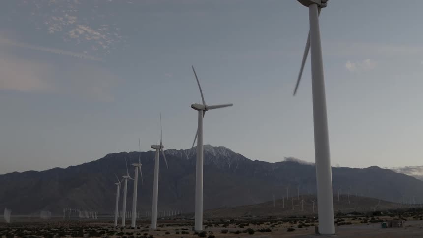 Row of wind turbines spinning in the wind