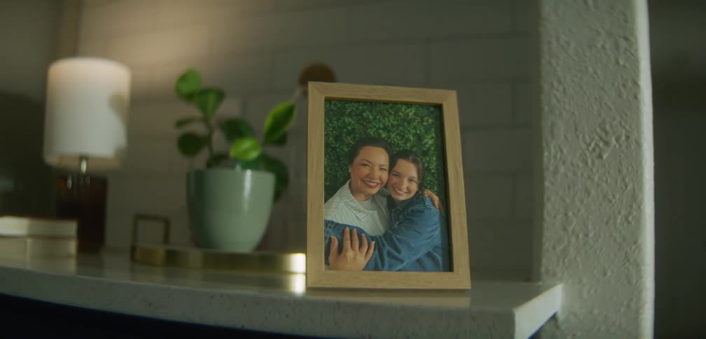 A photo of smiling mom and daughter on the mantel