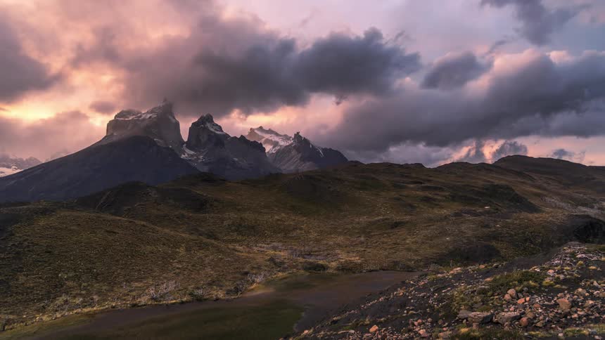Clouds are moving in the atmosphere above the rocky formation