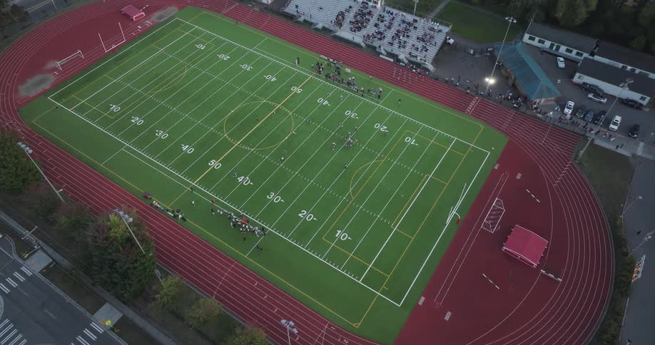 Slow approach toward the field during a Friday night high school football game