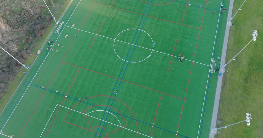 Youth soccer players practice various drills on different sections of the playing field