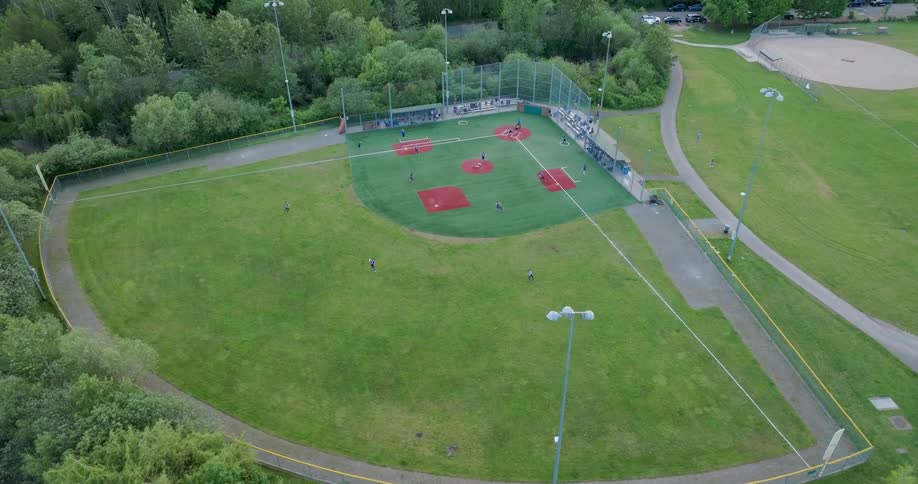 Orbiting around the outfield of a girls softball game