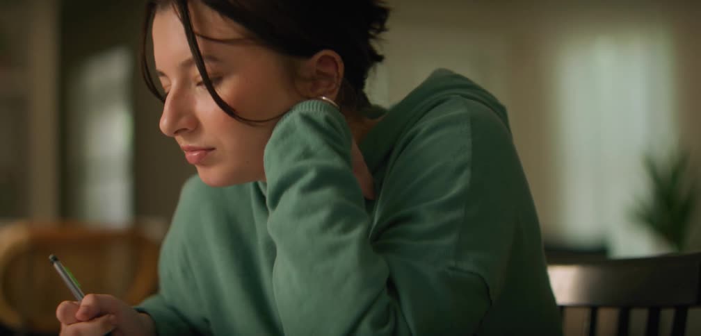 A young female is sitting at a table and studying