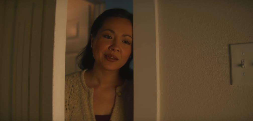 A mom smiles and closes the door after looking in on her child
