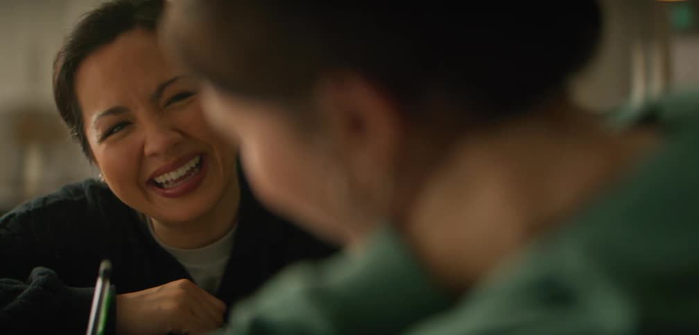 Mother smiles at her daughter as she helps with her homework