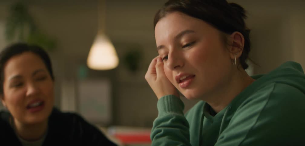 Two females are sitting at a table and having a conversation during a study session