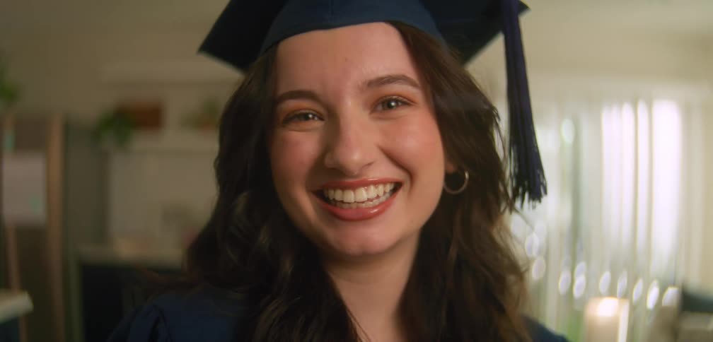Young woman posing for photos in her graduation cap and gown