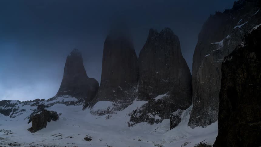 A storm covers the mountain in fog