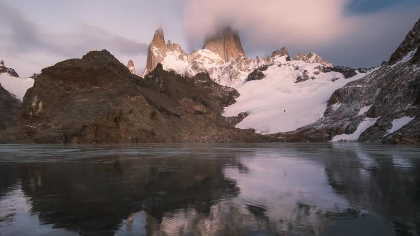 A mountain range is reflecting onto the body of water