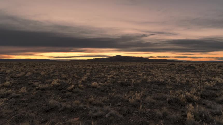 Time lapse of sunrise over a landscape under rolling clouds