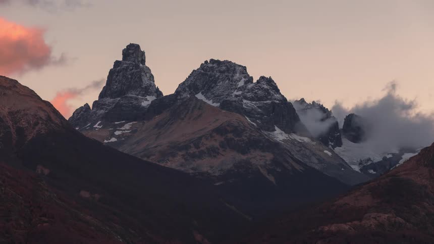 Mountainous scenery with snowy peaks and snowy clouds passing by