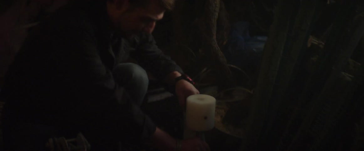 Person hammering in a dark area