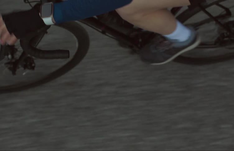 A man is cycling quickly on his bike on an empty road