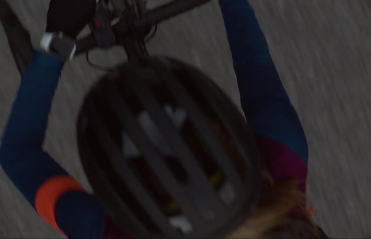 A person is wearing a helmet and riding a bicycle