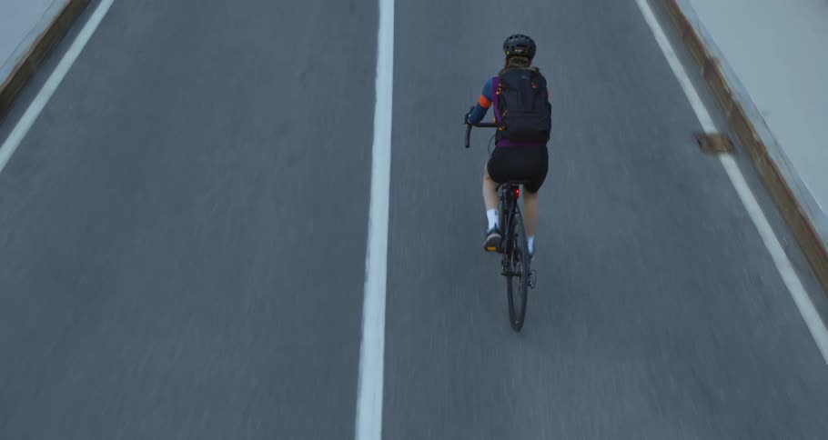 A man is riding his bicycle on an empty street