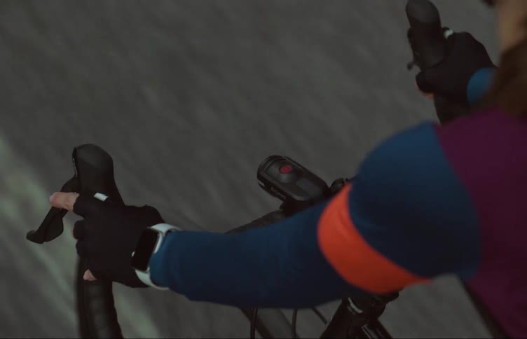 A female is riding a bicycle on a pathway outdoors