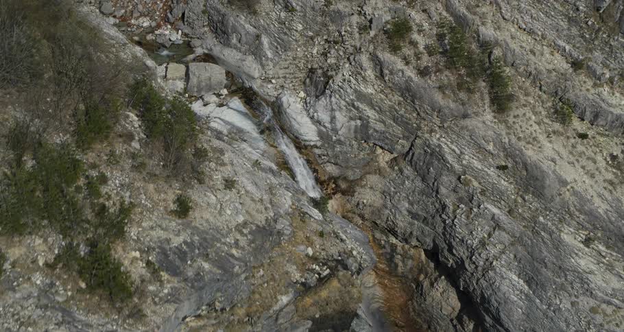 Waterfall is flowing on the side of a rock formation