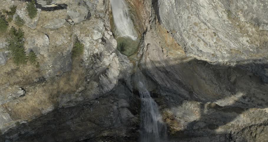 A river flows from the tops of a rock formation