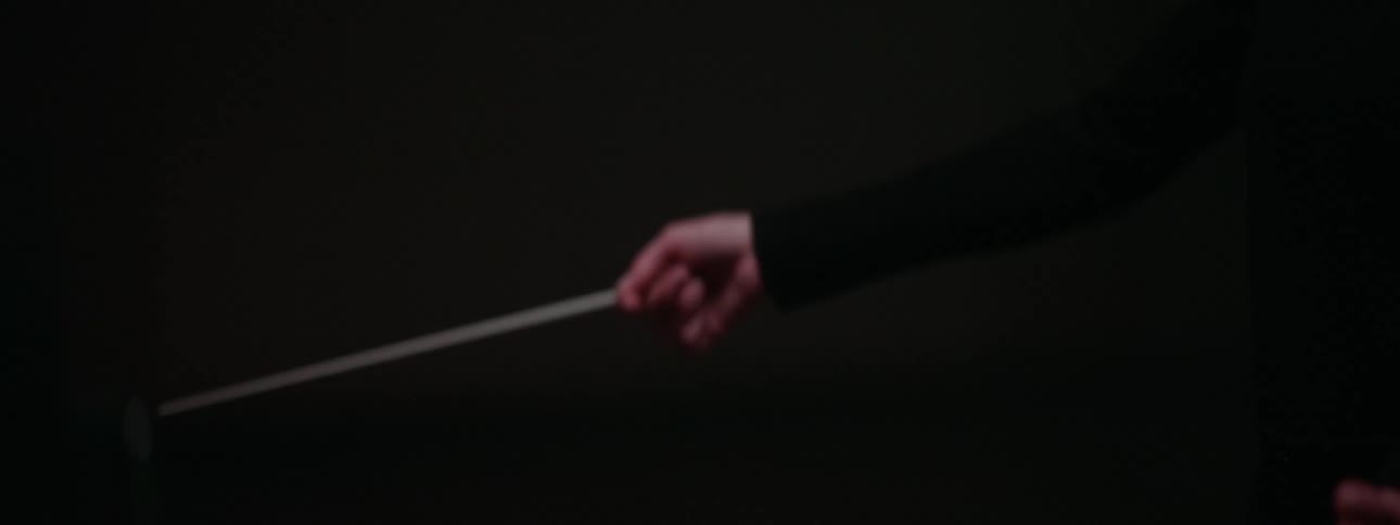 Conductor moves baton during an orchestral performance