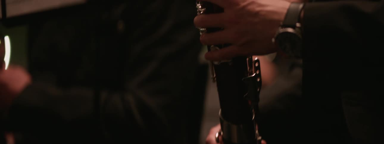 Closeup of a persons hands playing a saxophone
