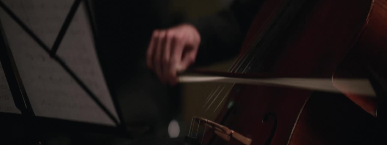 Two people are sitting down and playing an instrument
