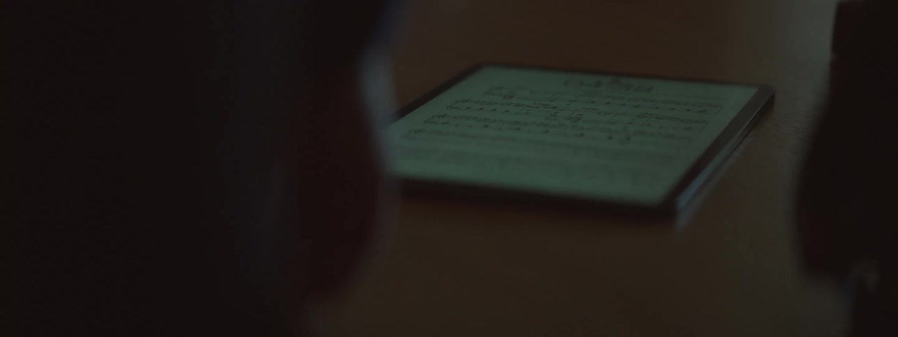 Person wakes up a tablet and picks it up off of the table