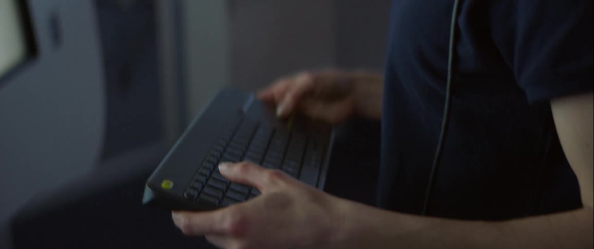 A person is holding and typing on a laptop