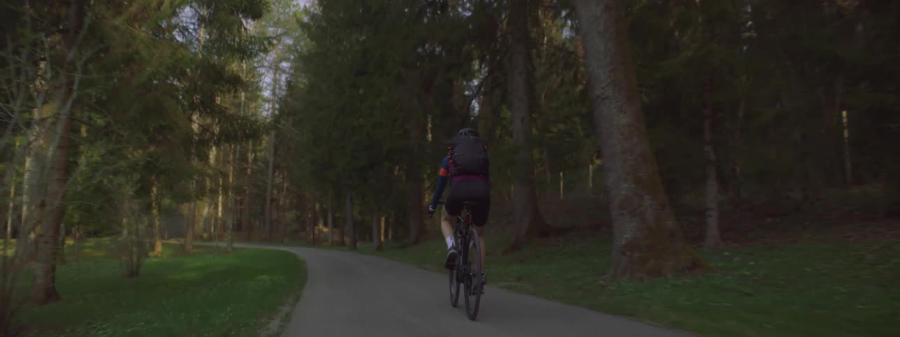 A cyclist is riding through a park during spring season