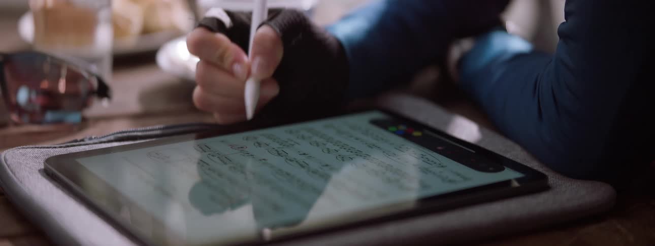 Person marking sheet music on their tablet using a tablet pen