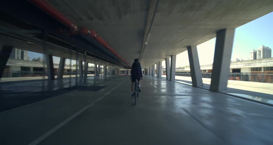 Person riding a bicycle in a metropolis corridor