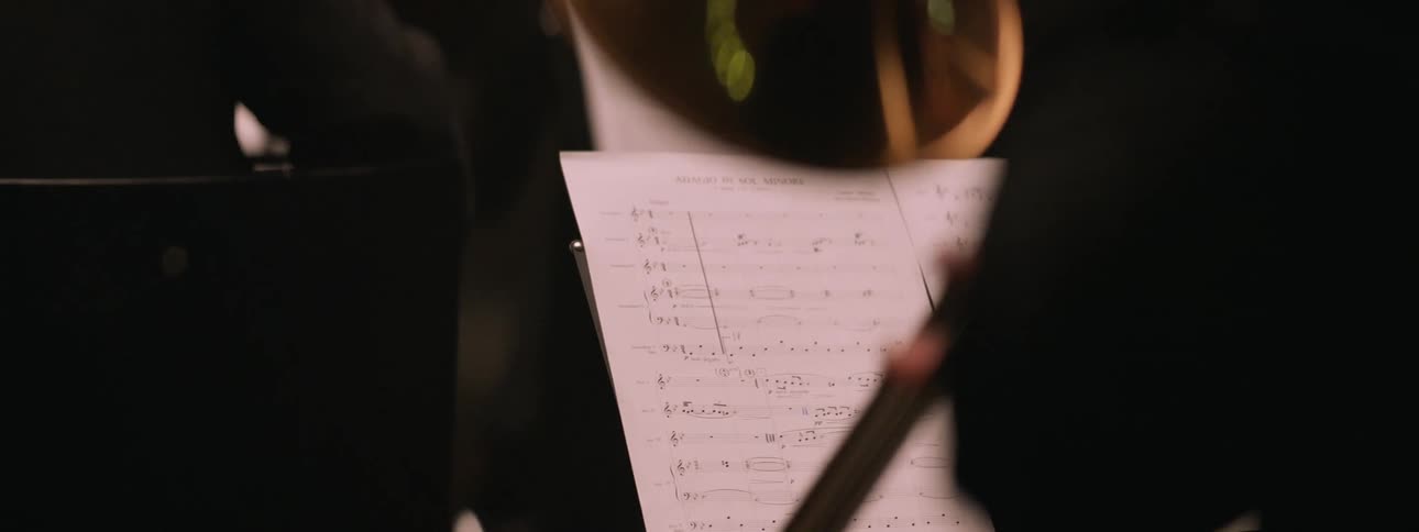 A closeup of a person playing a brass musical instrument