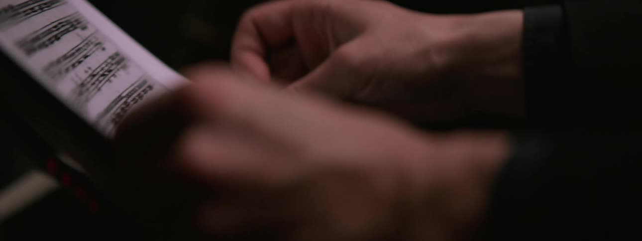 Human hands arranging a paper with some texts in a metal frame