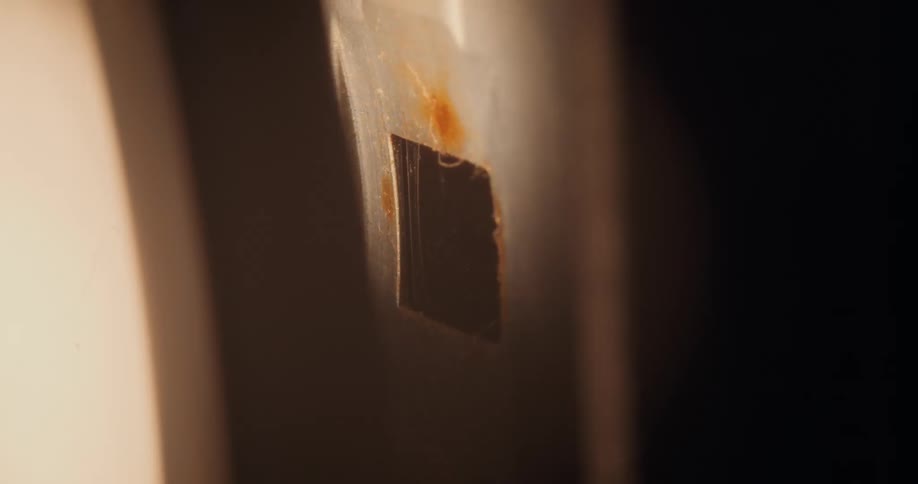 Closeup of a chip stuck to a surface and the shadow with light reflection passing and flashing quickly