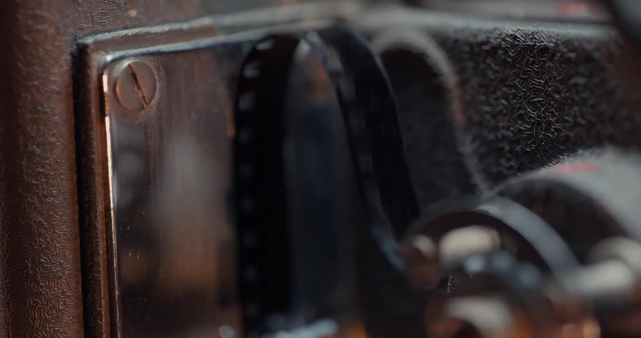 Close up of a strip of film moving through the gears of a vintage film projector