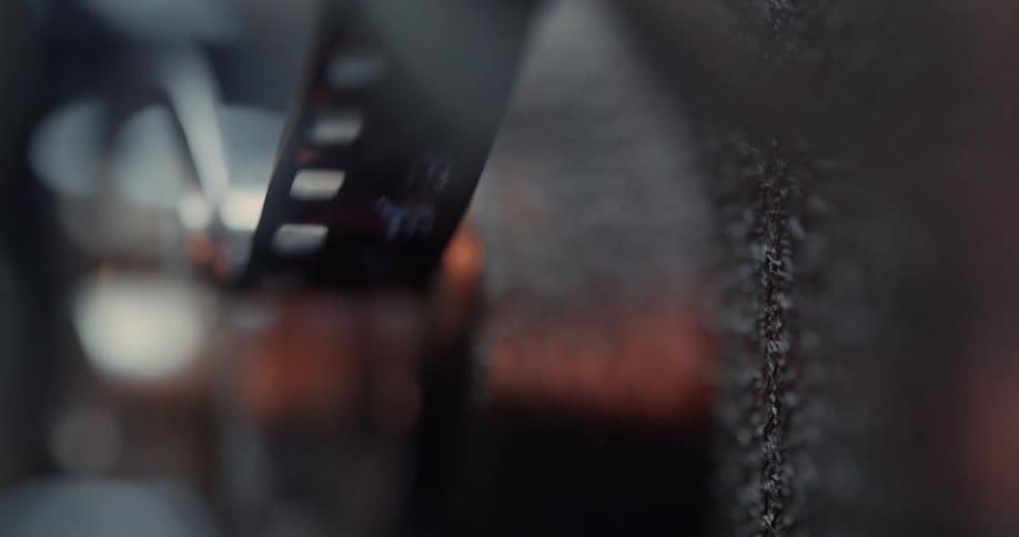 A roll of film is continuously spooled as parts of a machine move