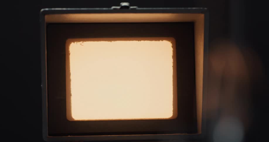 Close up of a bright light in the window of a projector booth