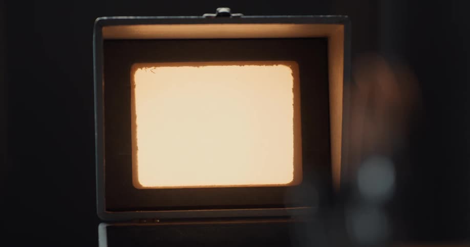 Framed light turns on and off while a machine spins behind it